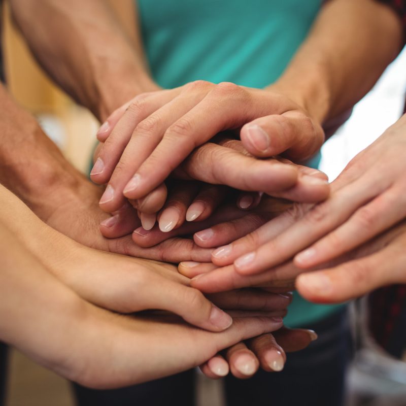 Close-up of business executives with hand stacked in office